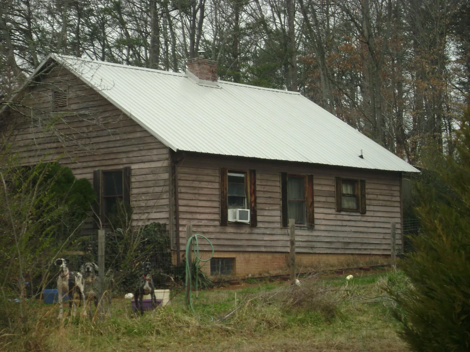 White metal roof on an old wood sided farmhouse, from a Metal Roof Installation job in Pittsboro